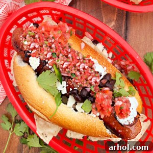 Sonoran hot dog with bacon, black beans, cotija cheese and salsa on bolillo roll on table