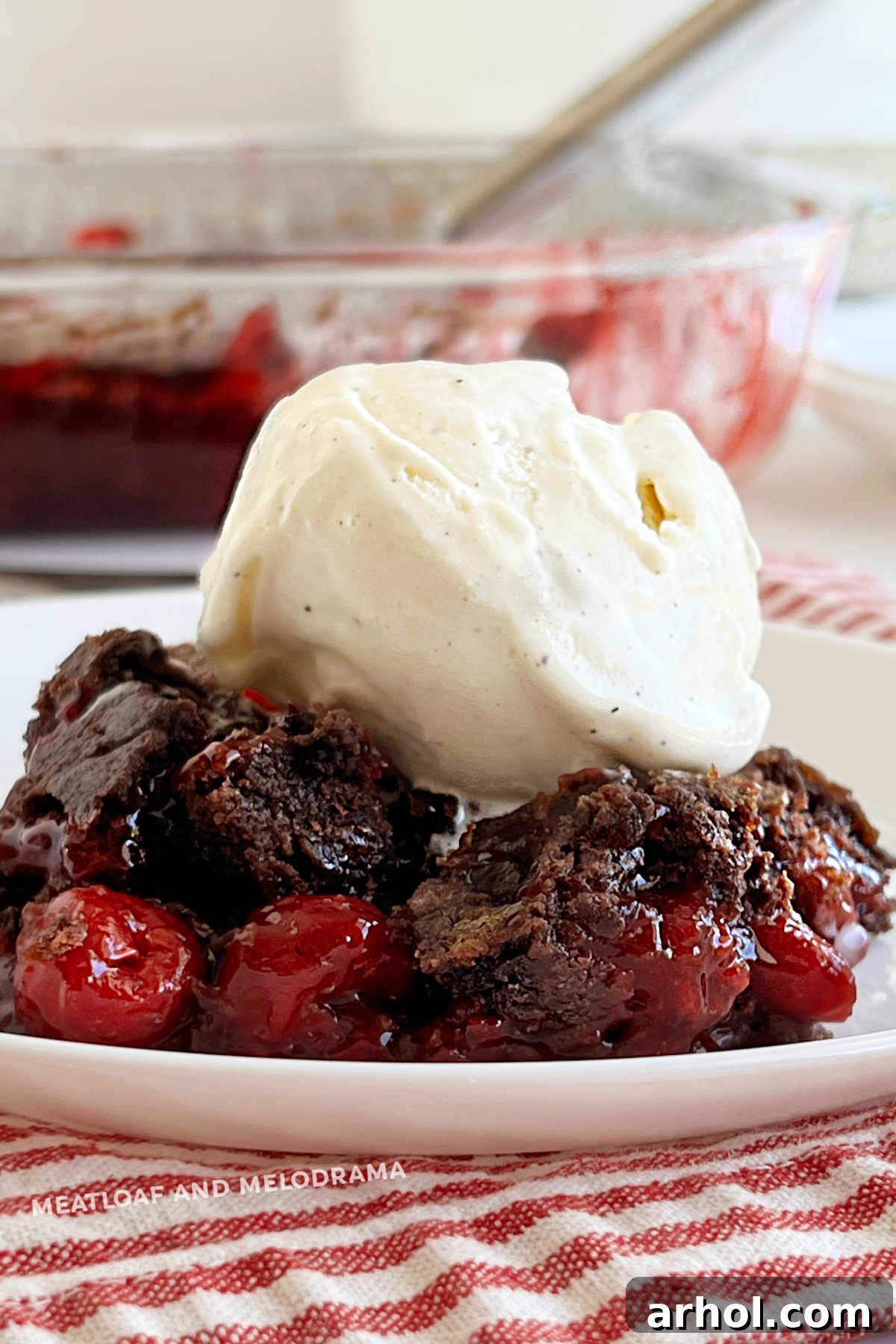 chocolate cherry dump cake with cherry pie filling topped with scoop of ice cream