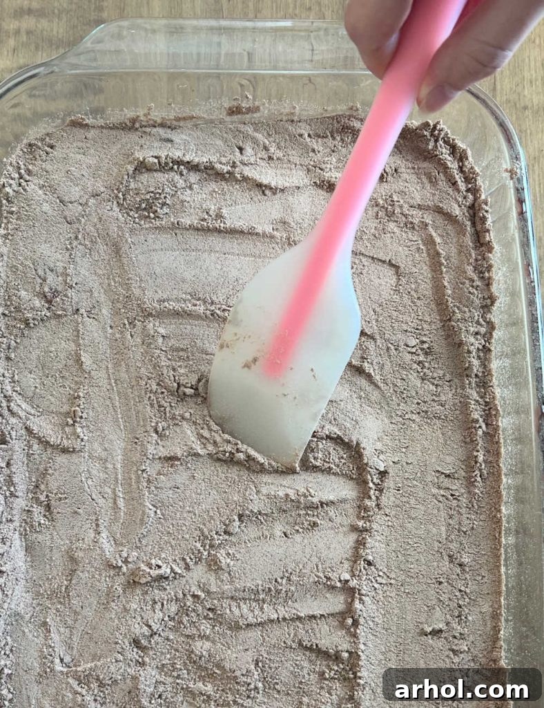 spread chocolate cake mix over pie filling with spatula