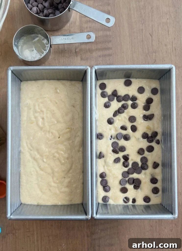 Two loaf pans filled with banana bread batter, one with chocolate chips visible, ready for baking.