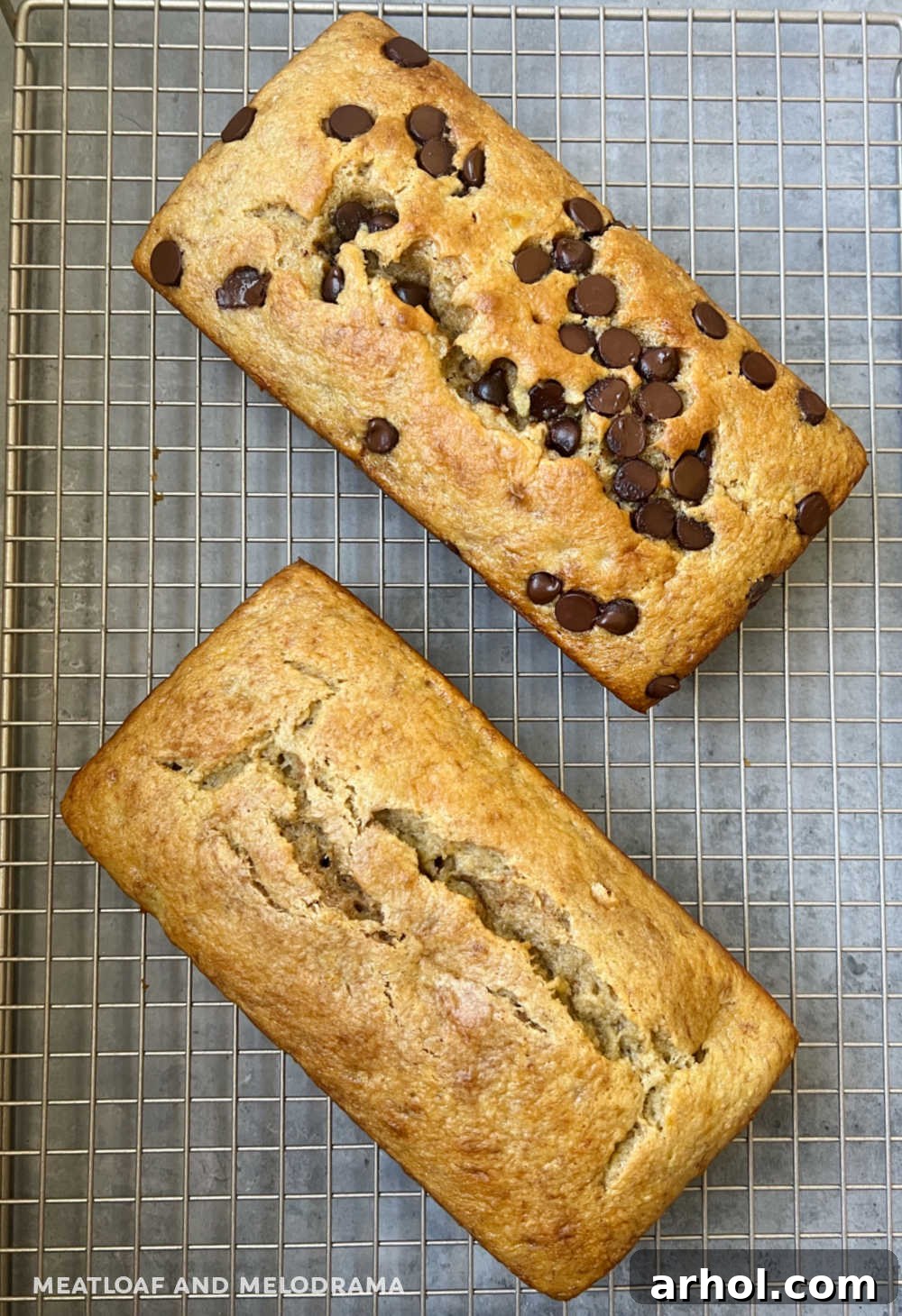 Two golden-brown loaves of cake mix banana bread, one with visible chocolate chips, cooling on a wire rack.