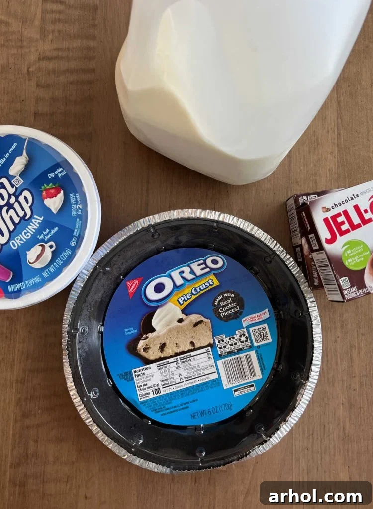 Ingredients for No Bake Chocolate Pudding Pie including an Oreo pie crust, Cool Whip whipped topping, milk, and Jell-O instant pudding mix boxes