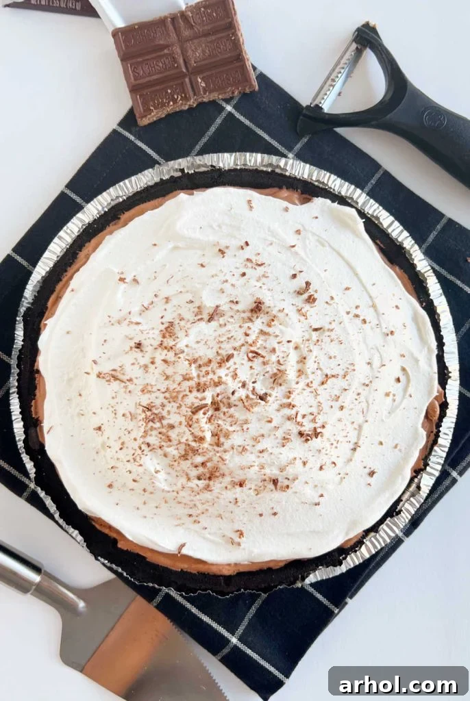 Finished No Bake Chocolate Pudding Pie topped with delicate chocolate shavings over the whipped topping, ready to chill