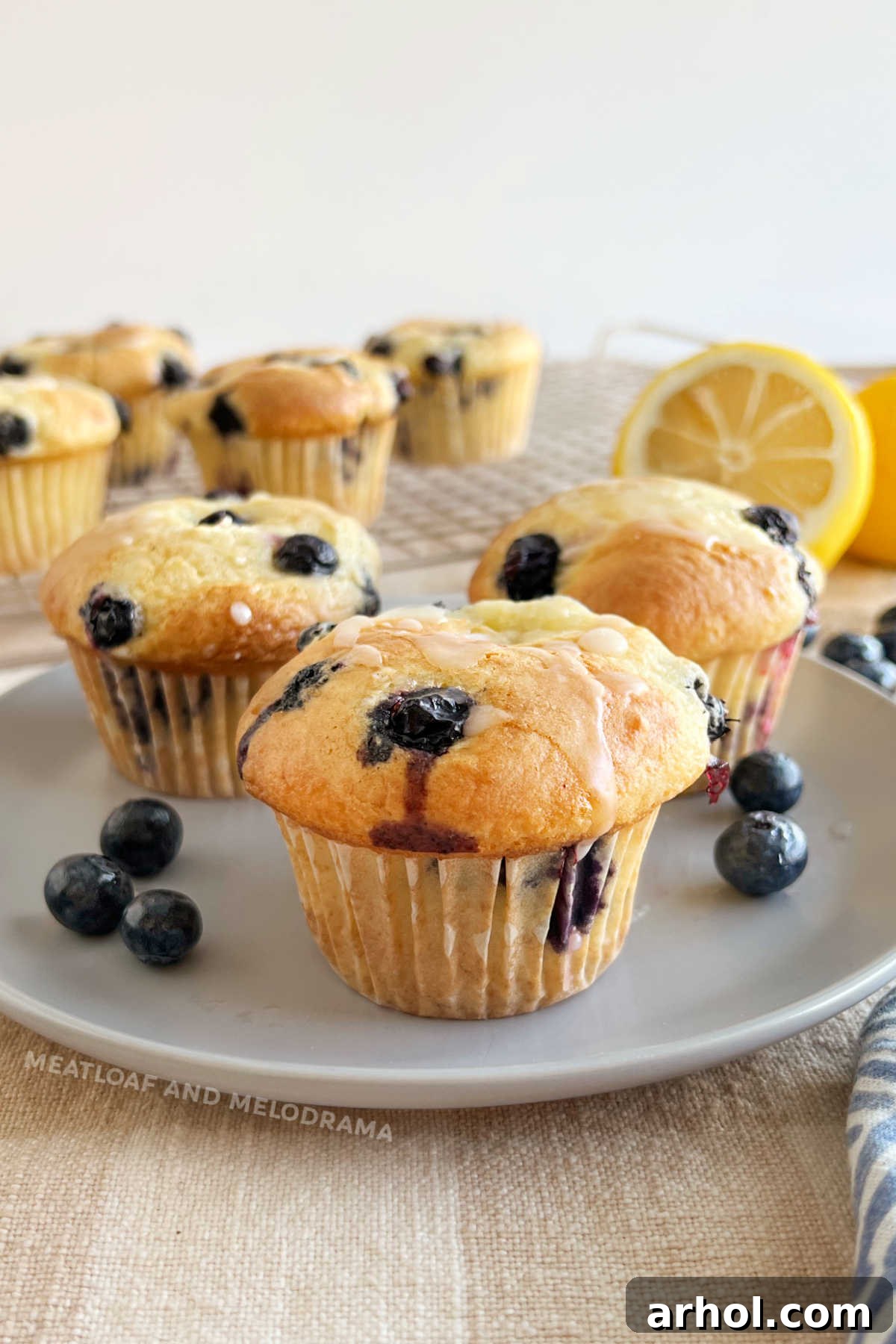 Delicious Cake Mix Blueberry Muffins with Zesty Lemon Glaze Golden-brown cake mix blueberry muffins with lemon glaze on a rustic wooden table, ready to be enjoyed