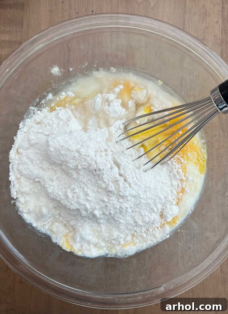 Preparing the Cake Mix Muffin Batter Mixing cake mix, eggs, melted coconut oil, and milk together in a large mixing bowl with a whisk until smooth