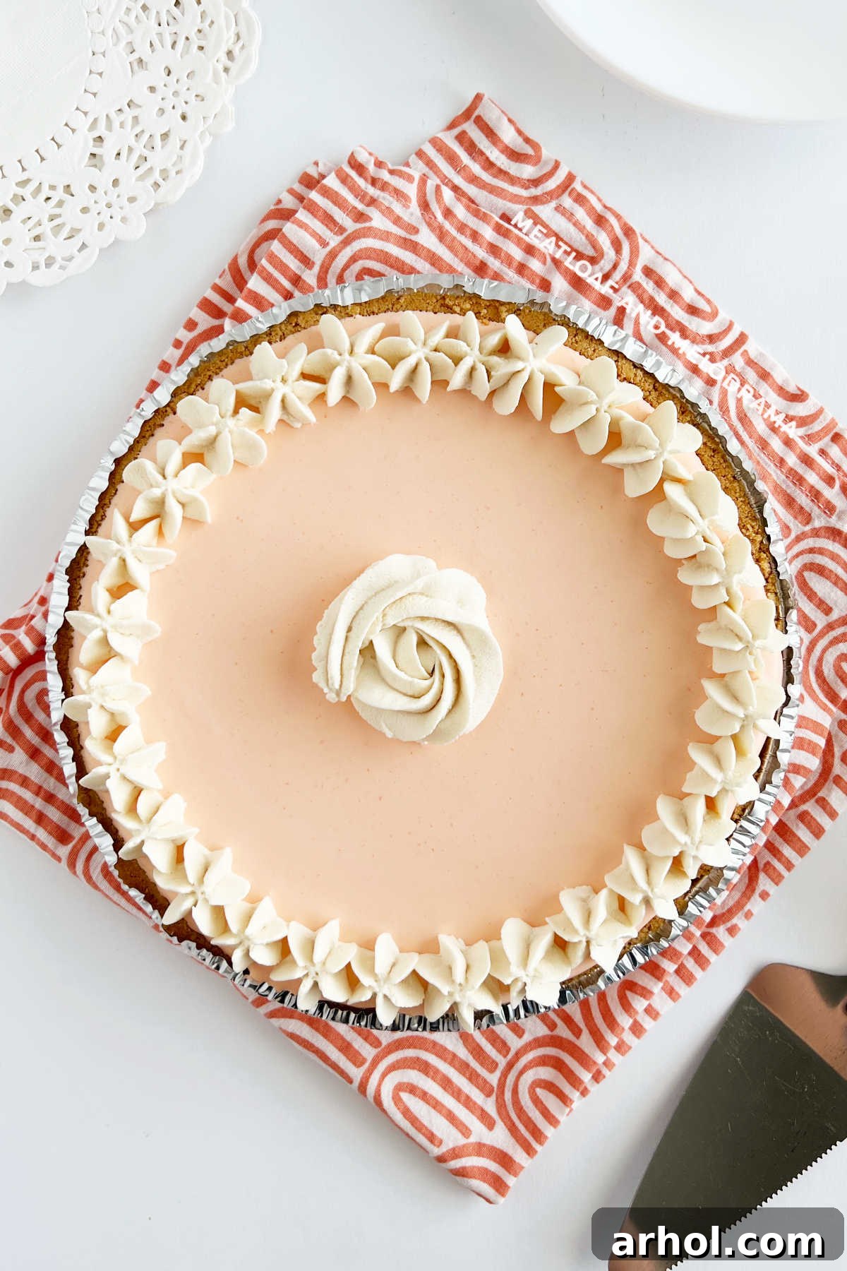 An overhead shot of a perfectly set no-bake creamsicle pie, elegantly decorated with piped whipped cream roses and star patterns, showcasing its smooth texture.
