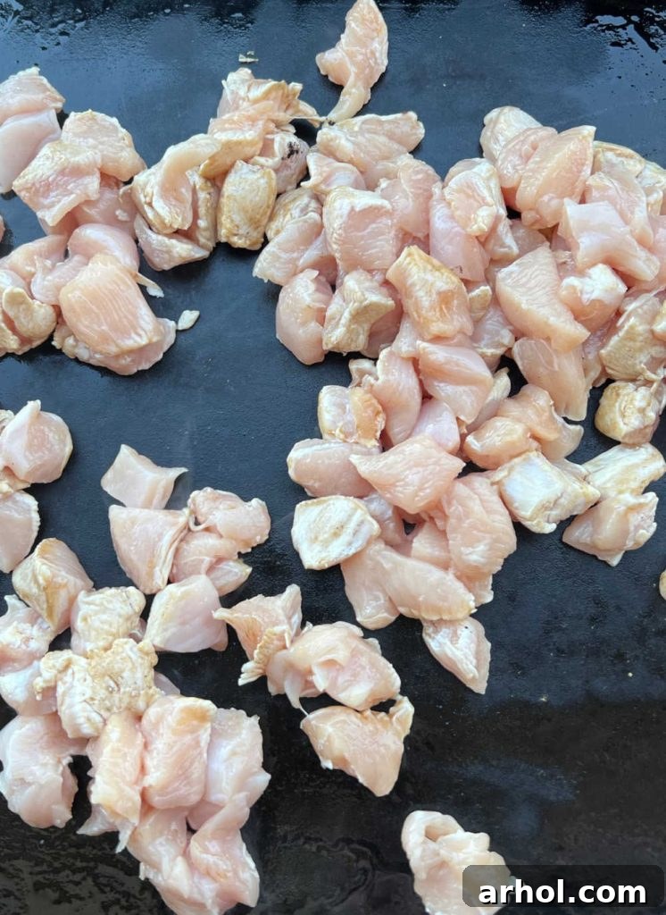 cut up chicken breasts cooking on blackstone griddle