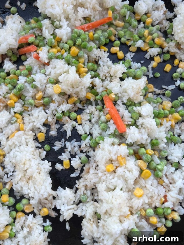 jasmine rice and frozen vegetables cooking on blackstone griddle