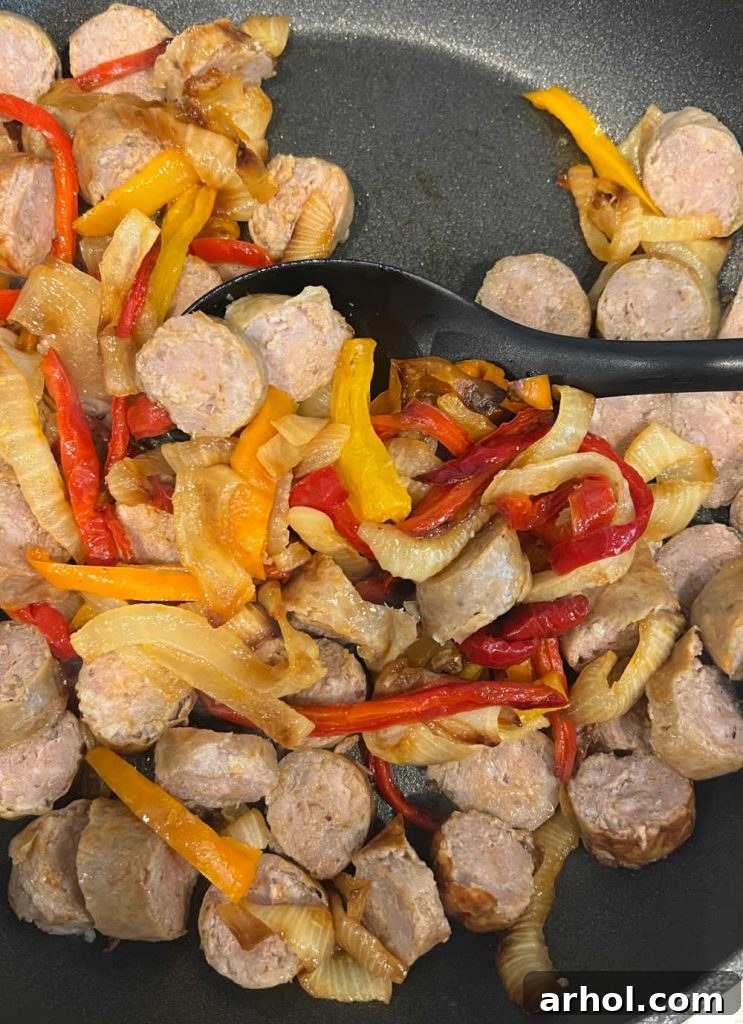 Heat leftover Italian sausage slices with bell peppers and onions in a skillet until warmed through and vegetables are tender.