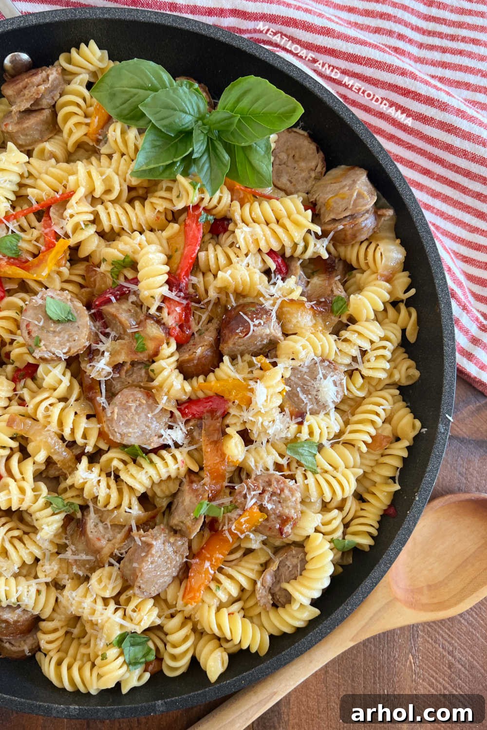 Leftover Italian sausage and peppers pasta with fresh basil in a skillet, ready to be served.