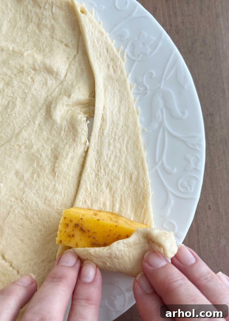roll peach slice in crescent roll triangle