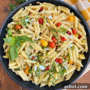 penne pasta with grape tomatoes and fresh basil and feta cheese in skillet