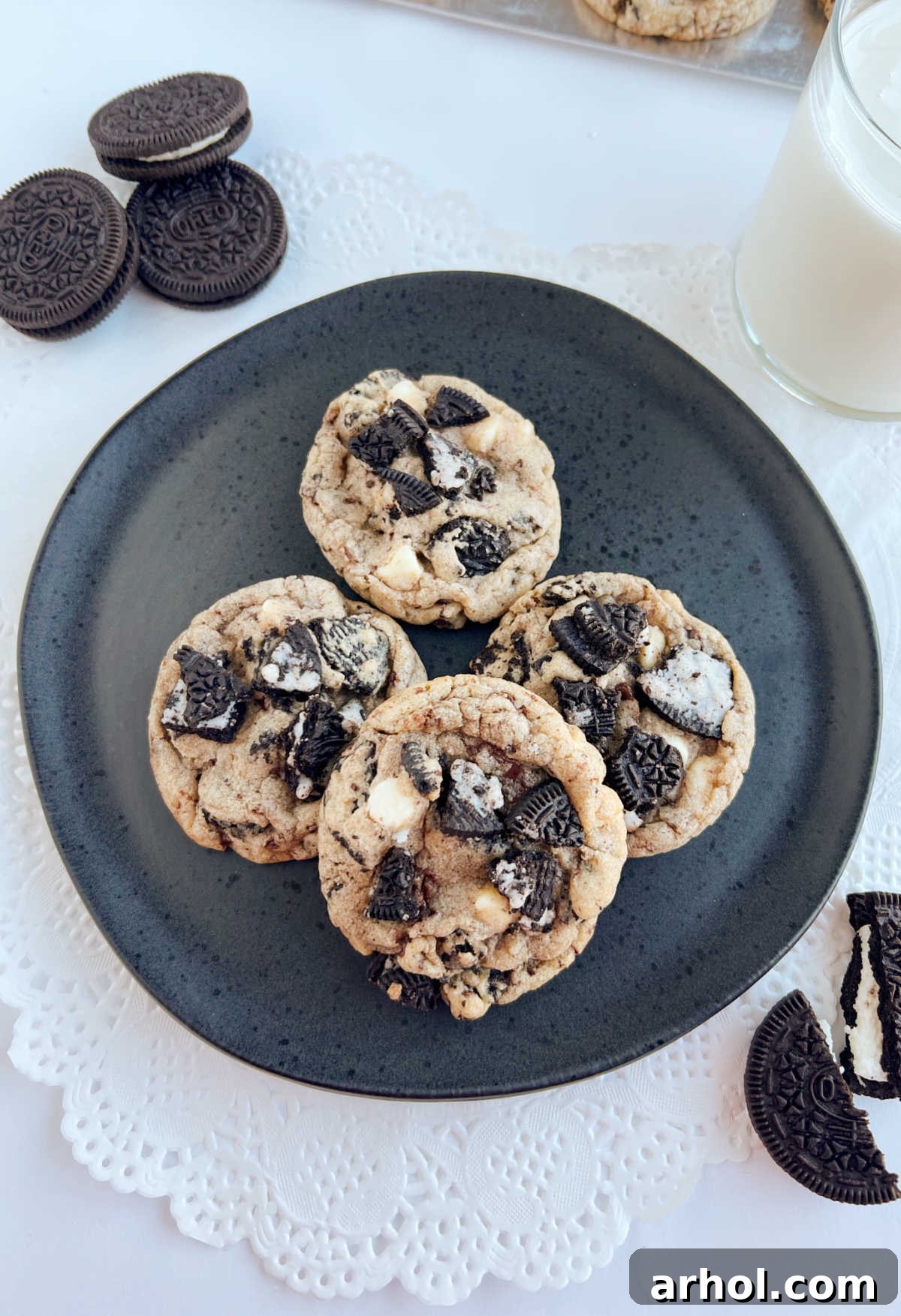 Freshly baked Oreo Chocolate Chip Cookies with Oreo cookie pieces and a glass of cold milk, ready to be enjoyed.