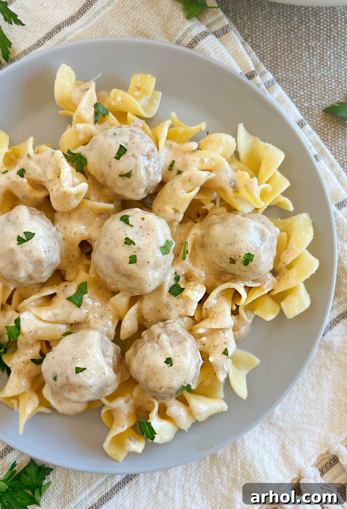plate of slow cooker Swedish meatballs and gravy over egg noodles