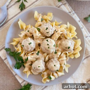 slow cooker swedish meatballs with creamy sauce over egg noodles