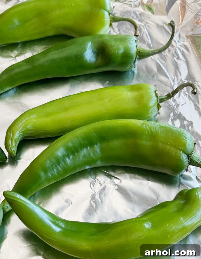 A vibrant pile of fresh green Hatch chile peppers, showcasing their characteristic elongated shape and bright green color.