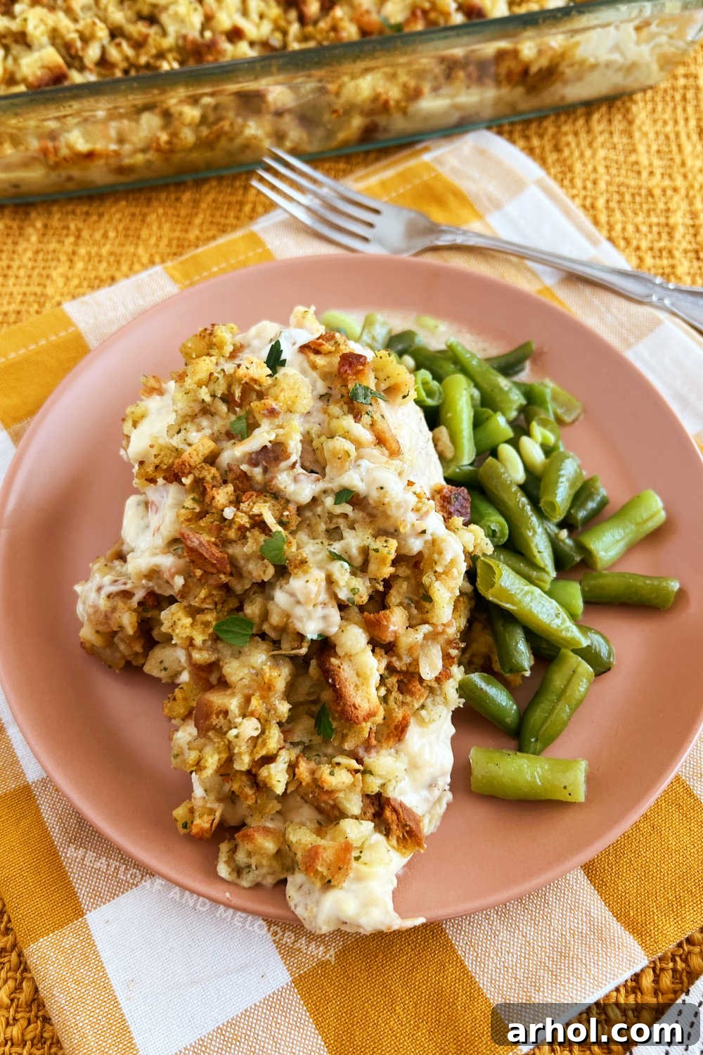 Golden-brown baked chicken breasts with savory Stove Top stuffing and fresh green beans served on a plate, ready to be enjoyed.