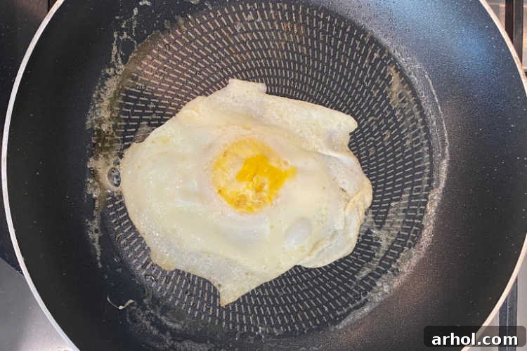 Golden Sausage Egg Cheese Sandwich 3 Perfectly fried egg in a frying pan, ready for a breakfast sandwich