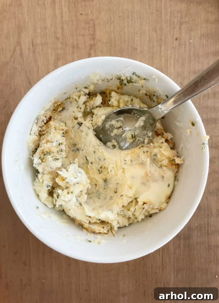 Mixing garlic butter spread with spoon