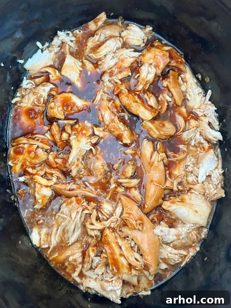Shredded teriyaki chicken cooking in the slow cooker