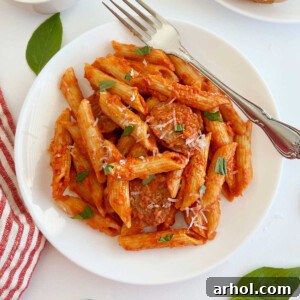 Penne alla Vodka with Italian sausage and fresh basil on a plate.