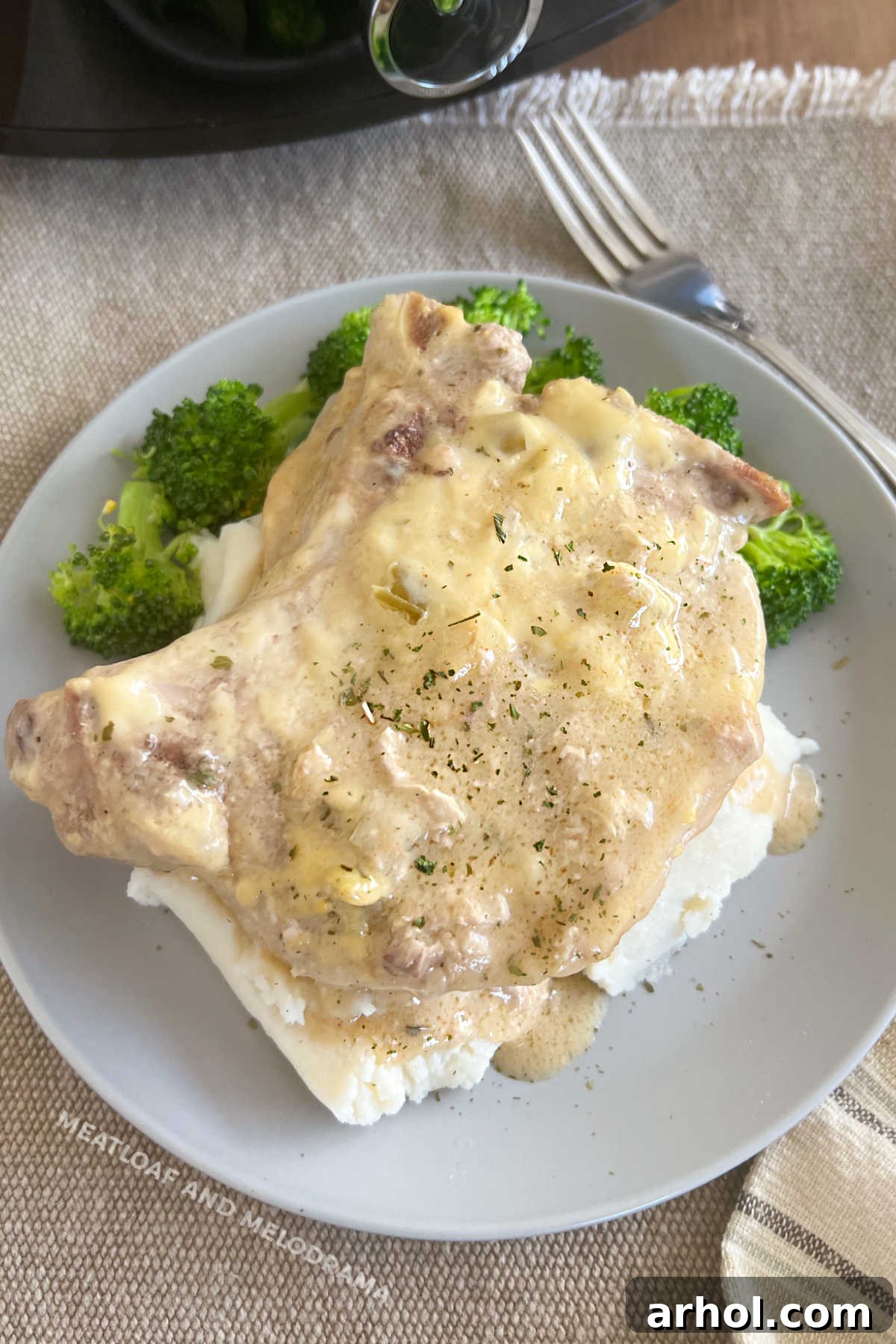 bone-in crockpot ranch pork chops with mashed potatoes and broccoli on plate