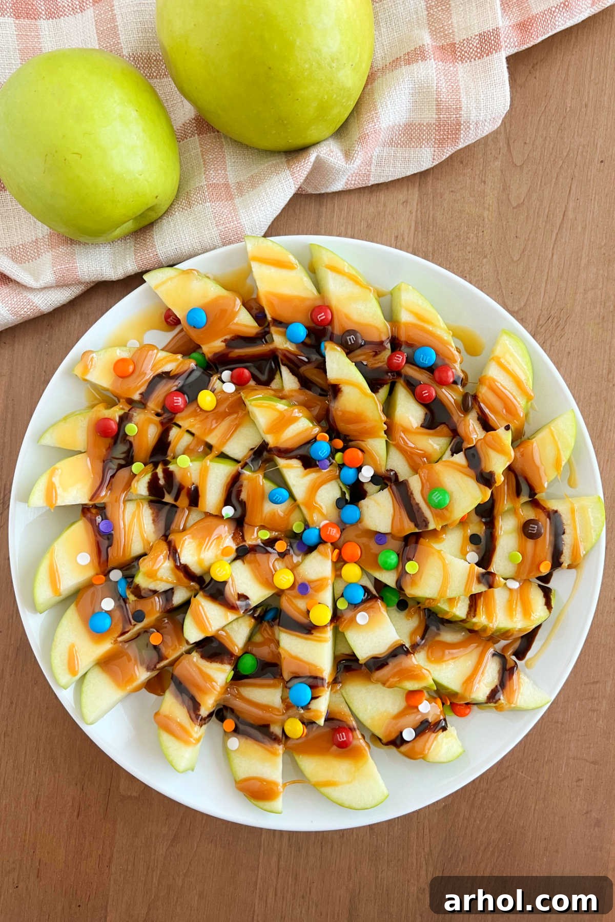 Caramel Apple Nacho Delight 2 A vibrant platter of caramel apple slices resembling nachos, adorned with chocolate drizzles and colorful candies, ready to be enjoyed by everyone.