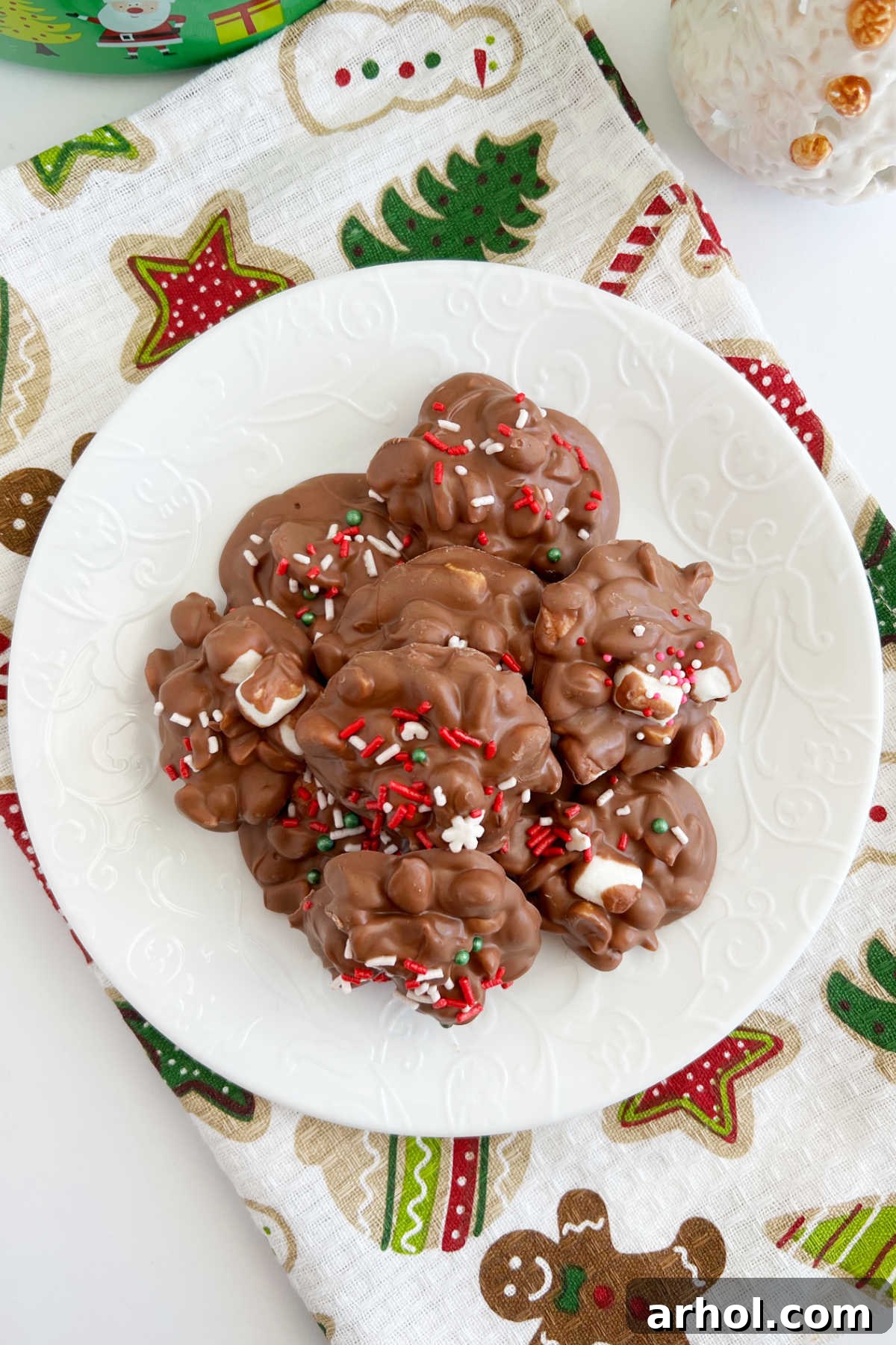 A festive plate filled with Crockpot Christmas Candy peanut clusters, beautifully decorated with holiday sprinkles, ready for serving.