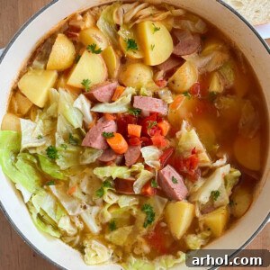 Cabbage Soup with Sausage, Potatoes, Tomatoes, and Carrots in a Dutch Oven