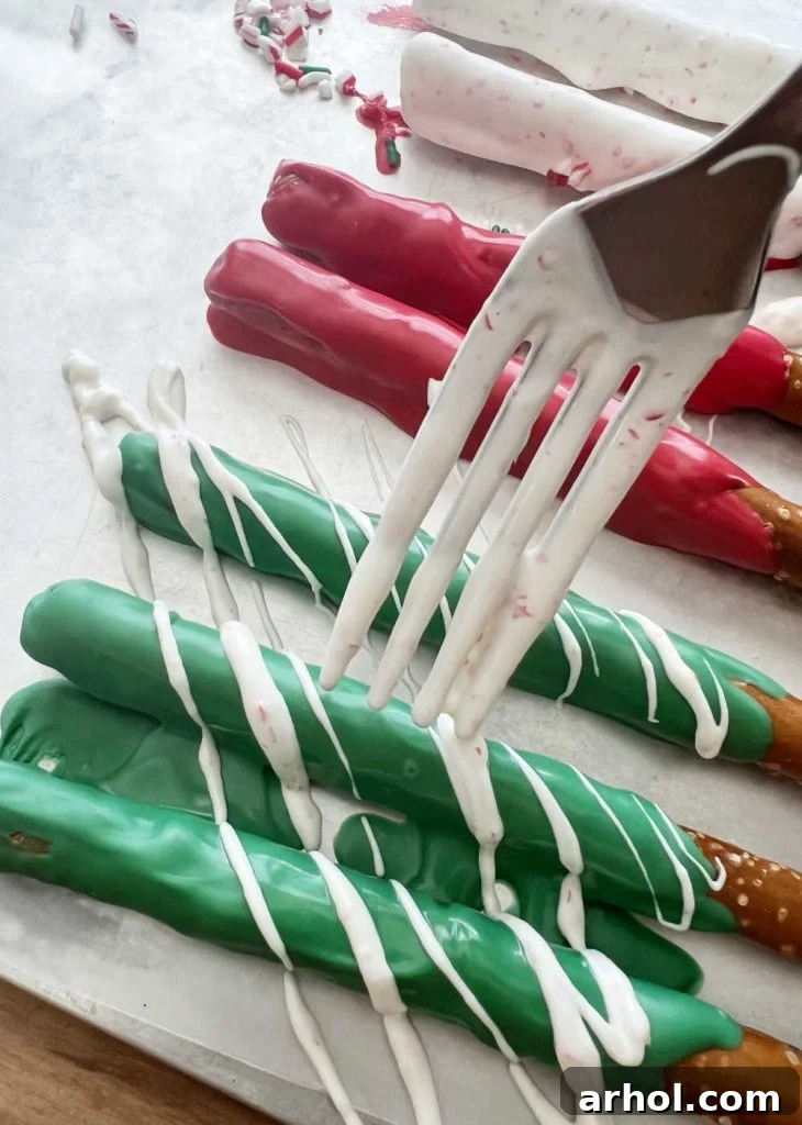 drizzling melted candy coating over already covered pretzels to add more color and design