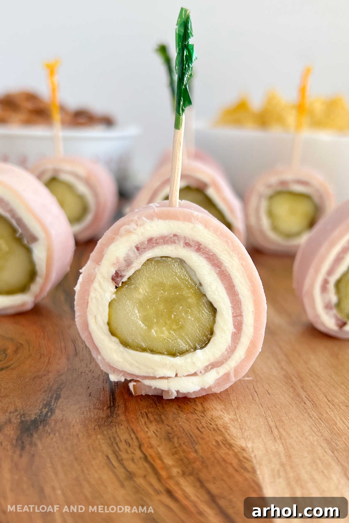 Delicious Ham Pickle Roll Ups with cream cheese on a vibrant charcuterie board, perfect for parties.