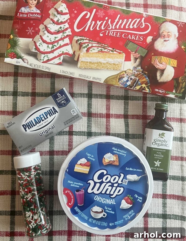 Little Debbie Christmas tree cakes, cream cheese, cool whip, vanilla and sprinkles ingredients on a counter