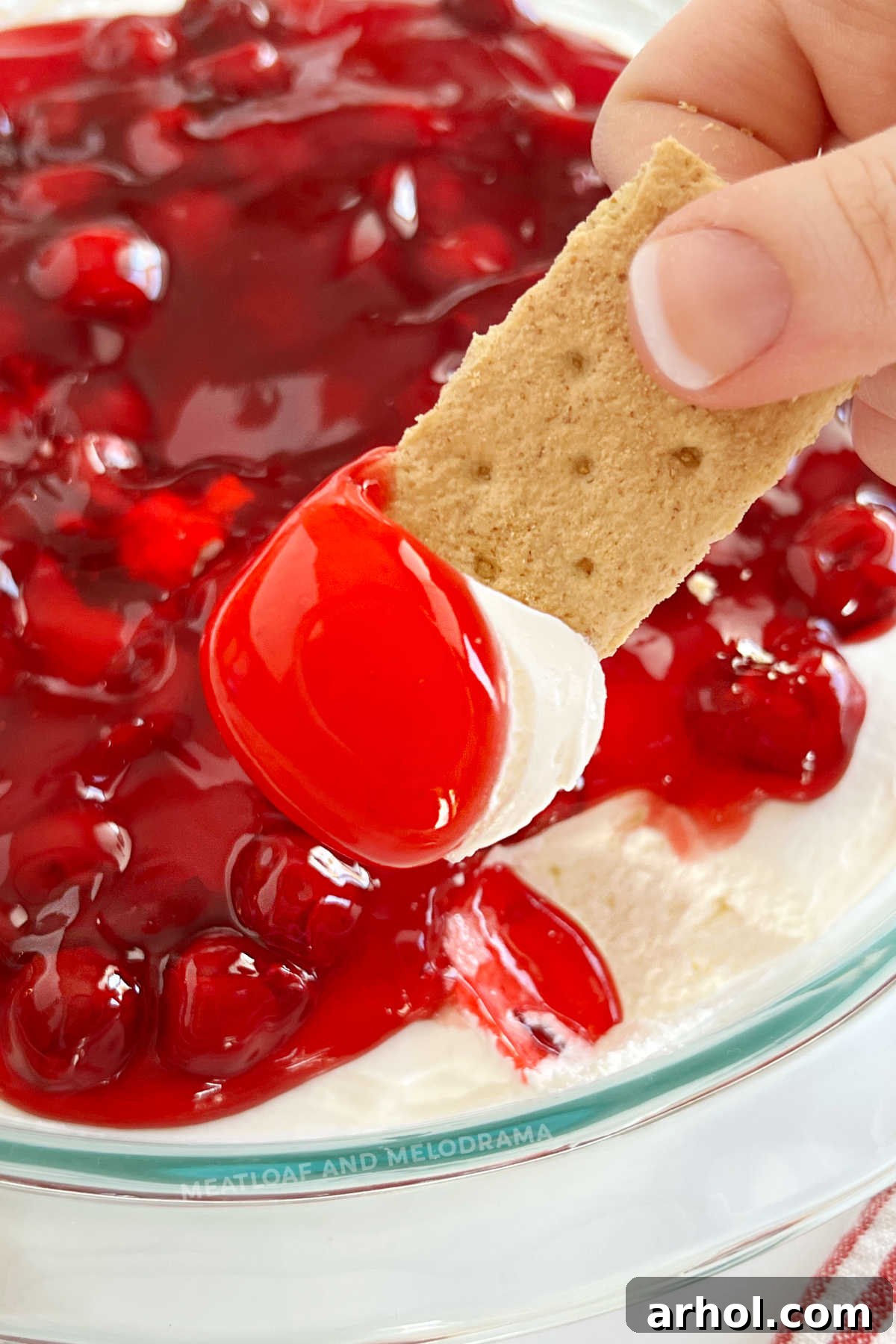 Luscious Cherry Cheesecake Dip 2 Cherry Cheesecake Dip with vibrant cherry pie filling on a graham cracker, ready for dipping