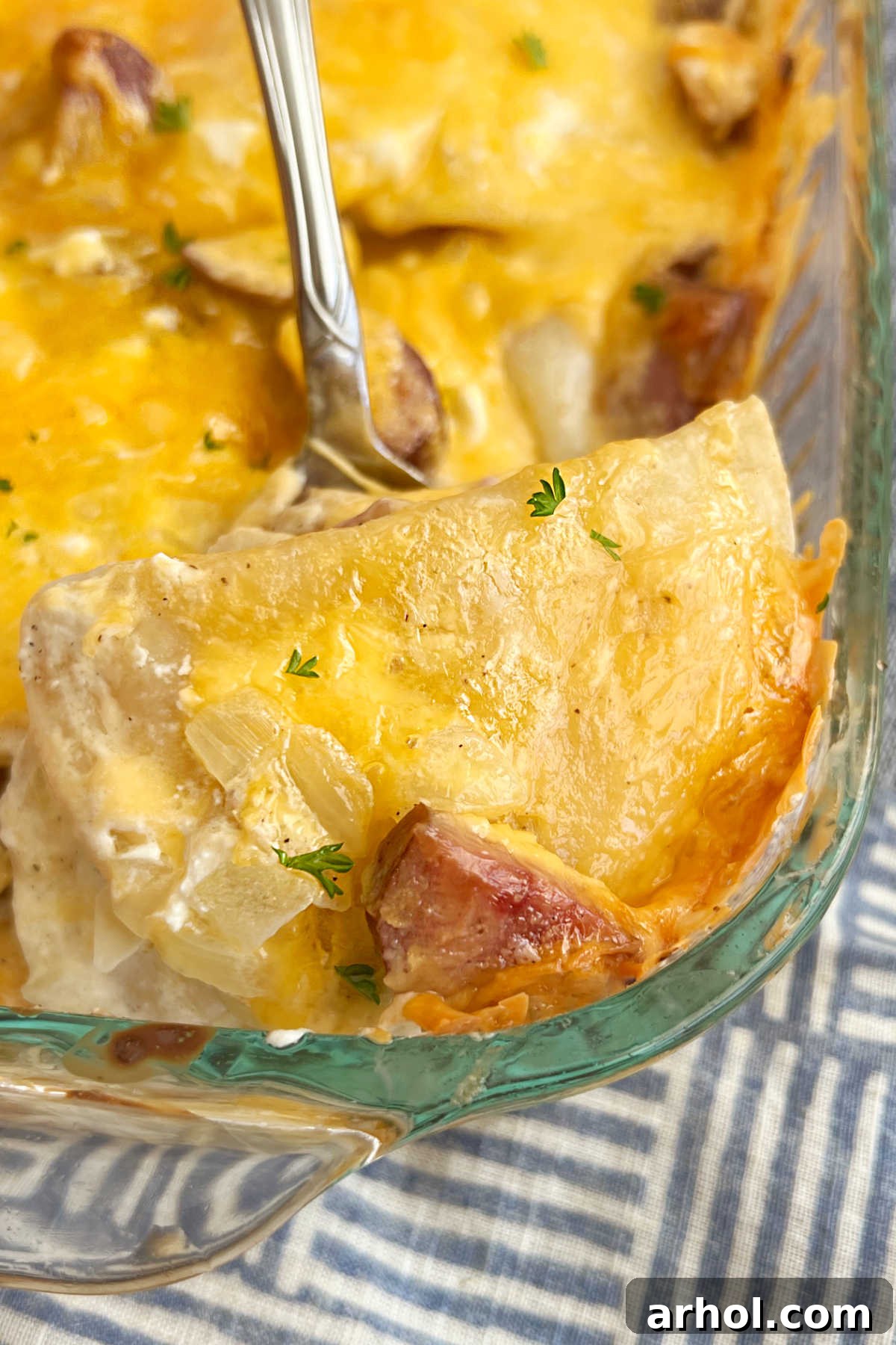 cheesy pierogi casserole with kielbasa on a serving spoon