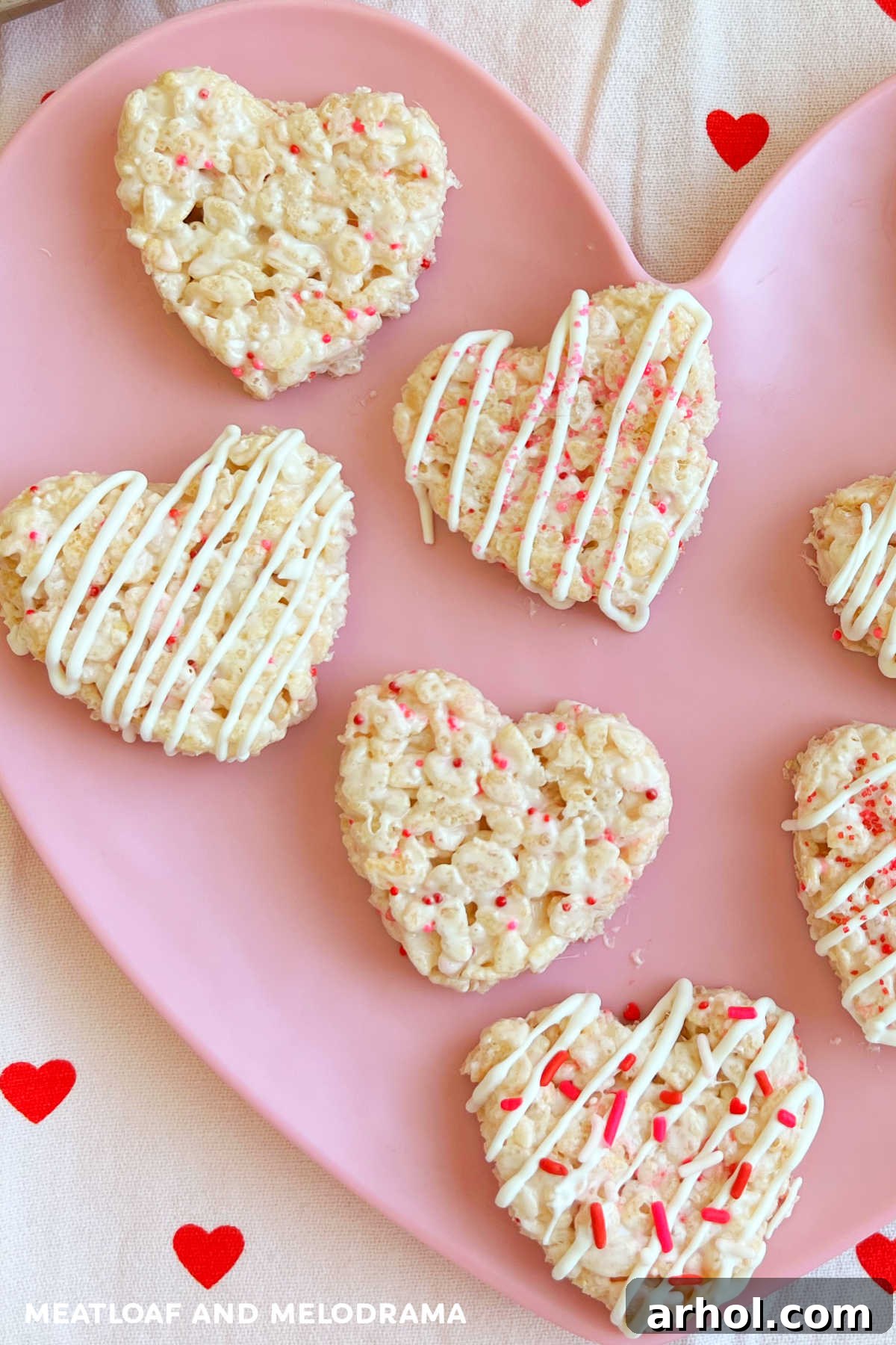 Heart-shaped Valentine's Rice Krispie Treats decorated with sprinkles on a pink heart plate