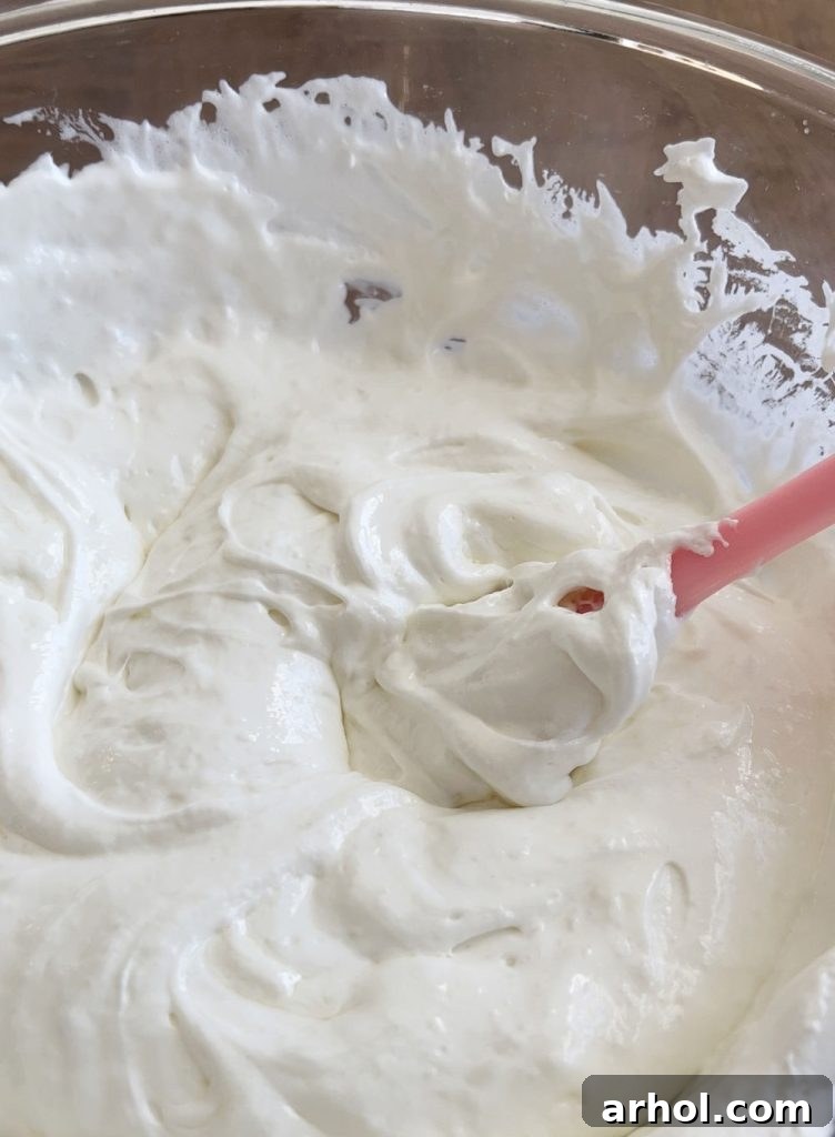 Stirring melted marshmallows and butter in a large bowl