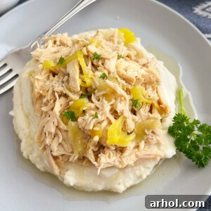 crock pot Mississippi chicken with pepperoncini peppers over mashed potatoes