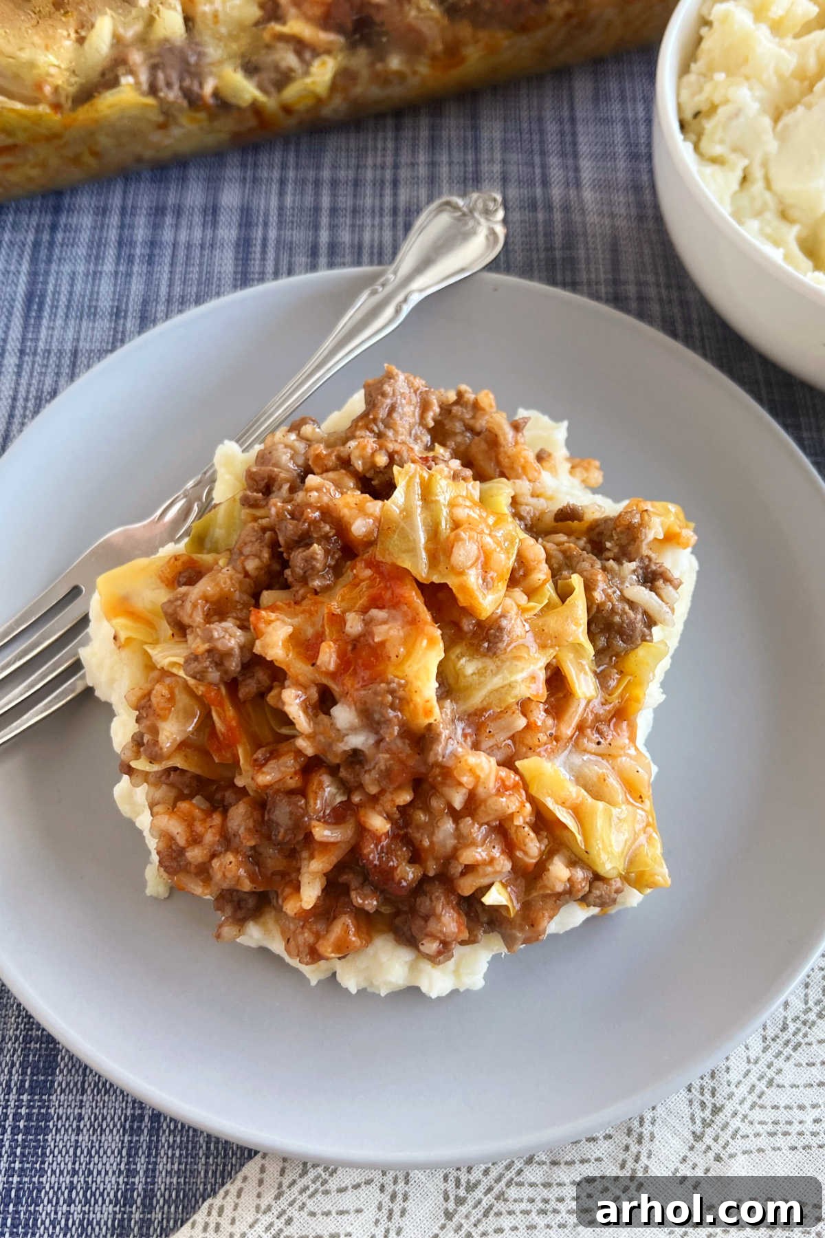 Cabbage Roll Casserole, or lazy Halupki, served with mashed potatoes on a blue plate