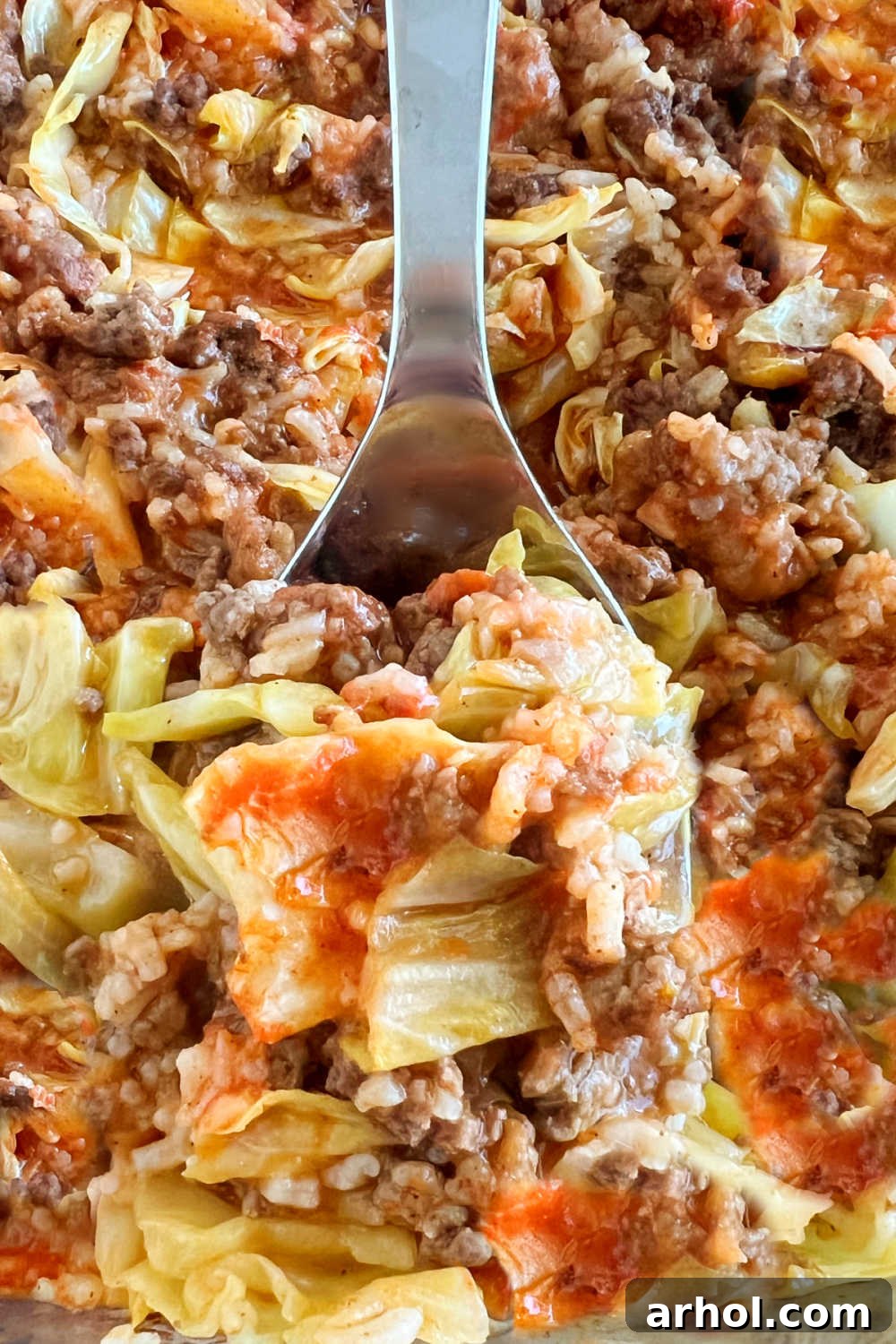 Baked cabbage roll casserole (lazy Halupki) on serving spoon