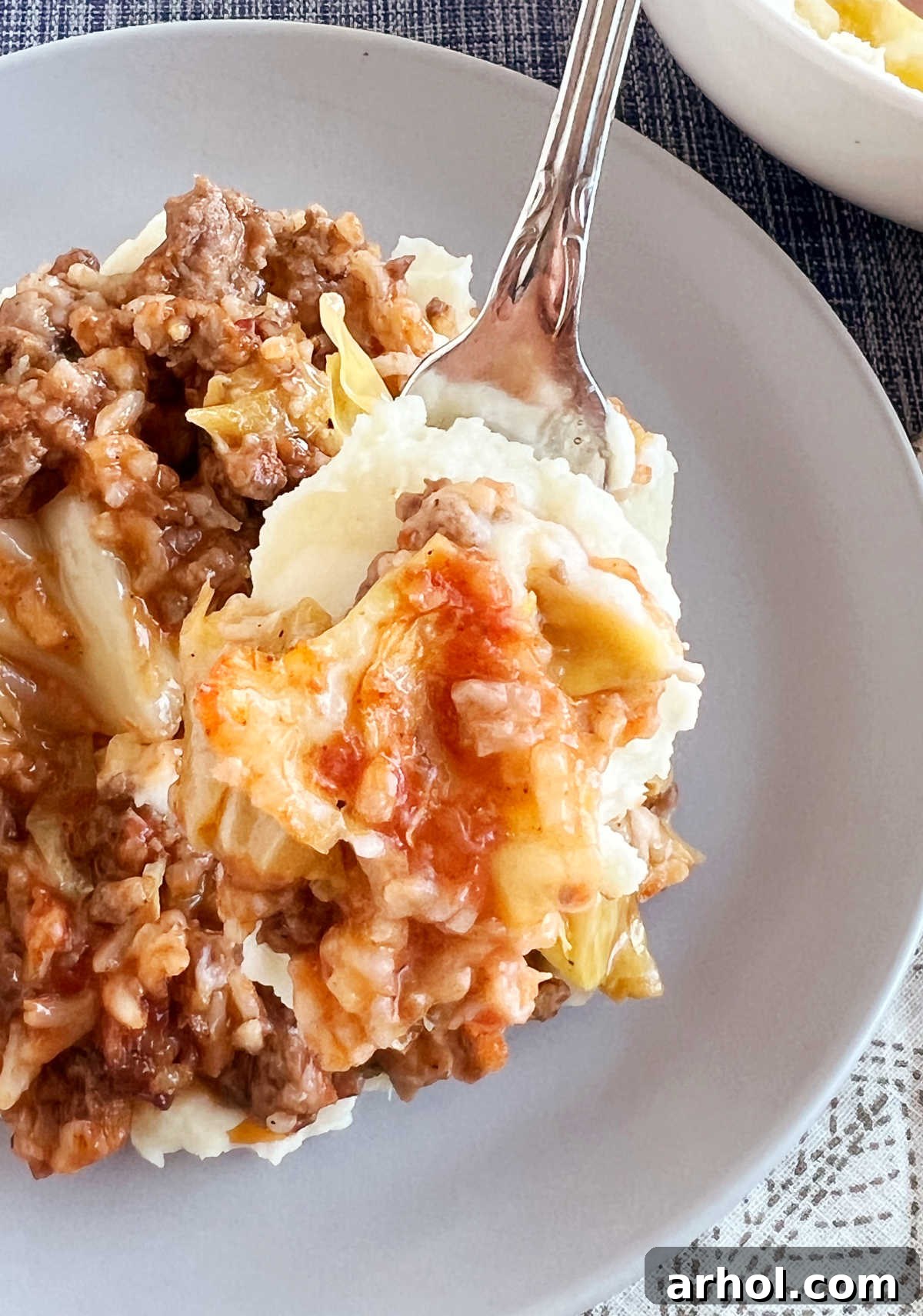 Unstuffed cabbage roll casserole (lazy Halupki) on a fork with mashed potatoes