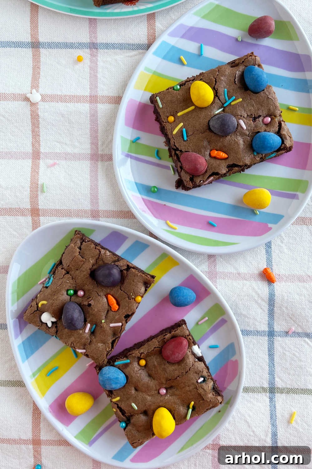 Mini Egg Magic Brownies 7 Perfectly sliced Easter brownies adorned with colorful Cadbury mini eggs and spring sprinkles, arranged for serving.