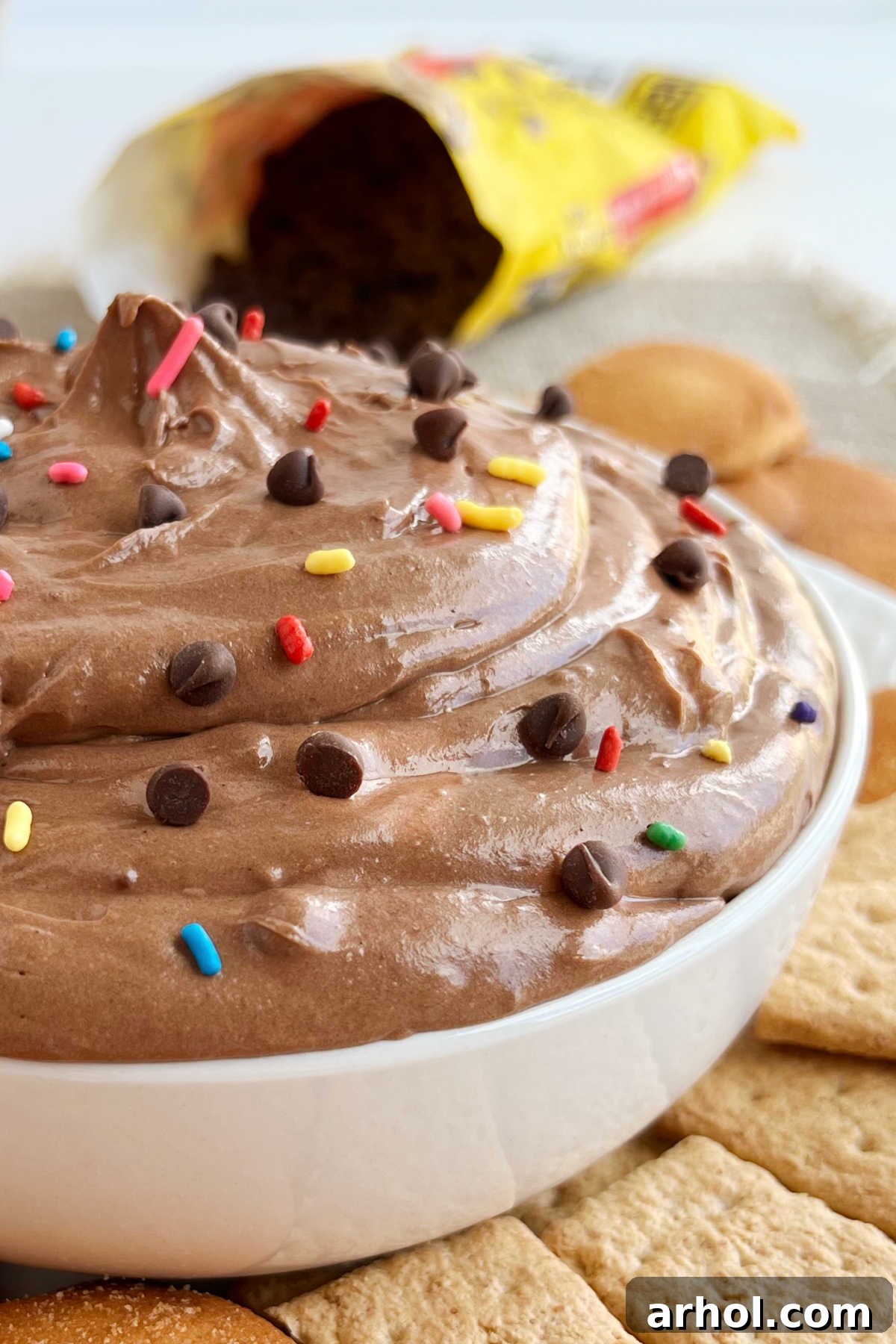 bowl of creamy brownie batter dip with chocolate chips and sprinkles