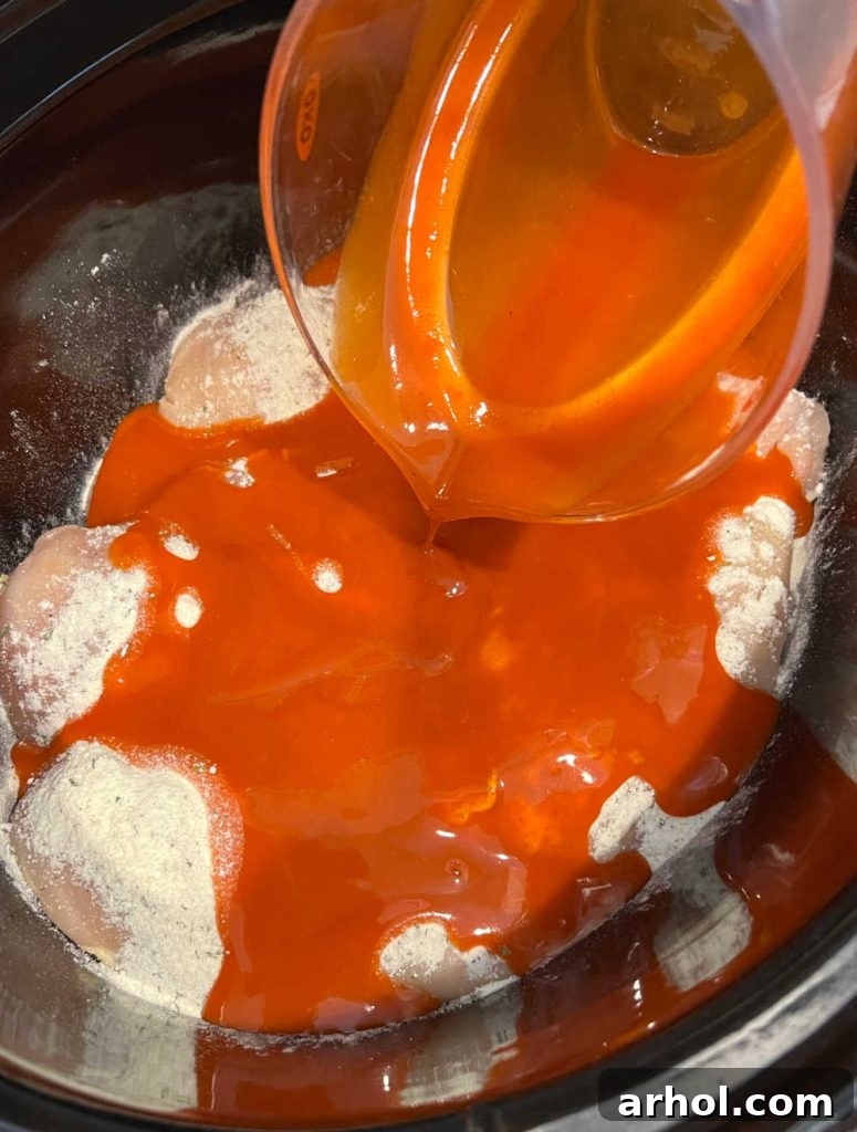 pour buffalo sauce over chicken in slow cooker