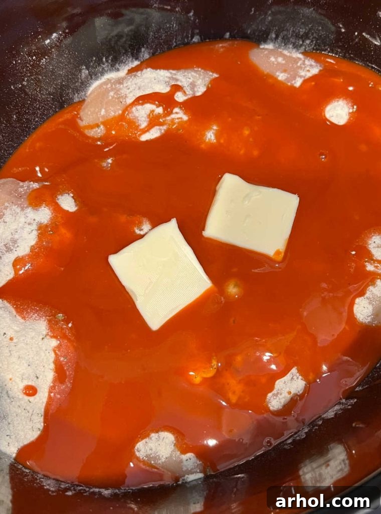 butter over buffalo chicken in slow cooker