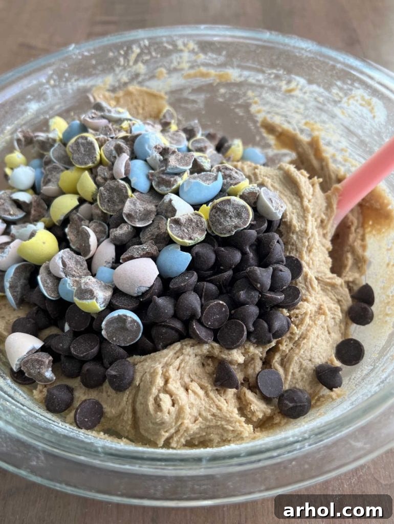 Mixing chocolate chips and chocolate eggs into cookie dough
