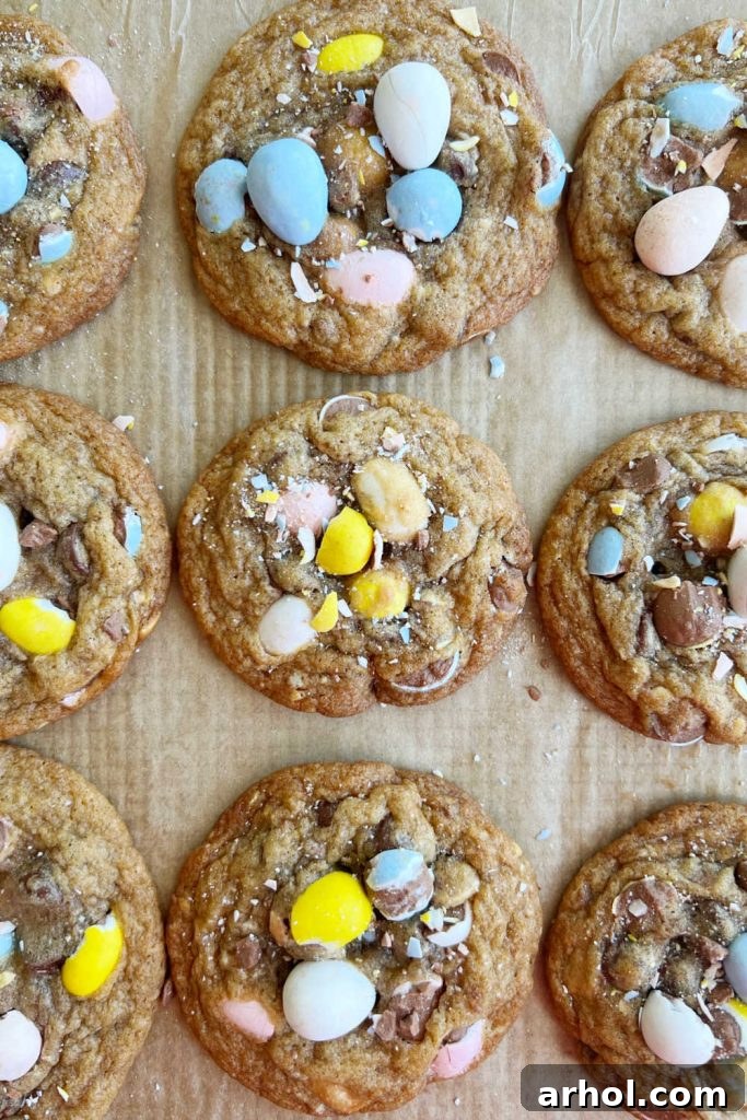 Baked Easter egg cookies on parchment paper lined cookie sheet, freshly out of the oven