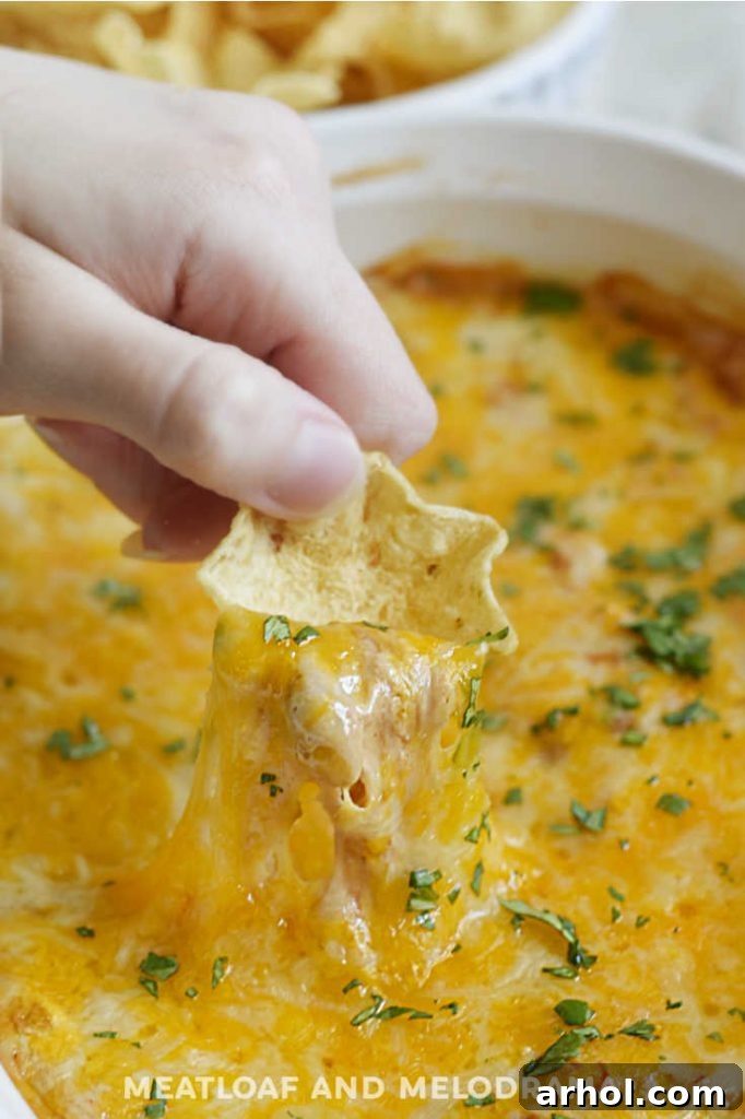cheesy hot bean dip on a crispy tortilla chip, ready to be eaten