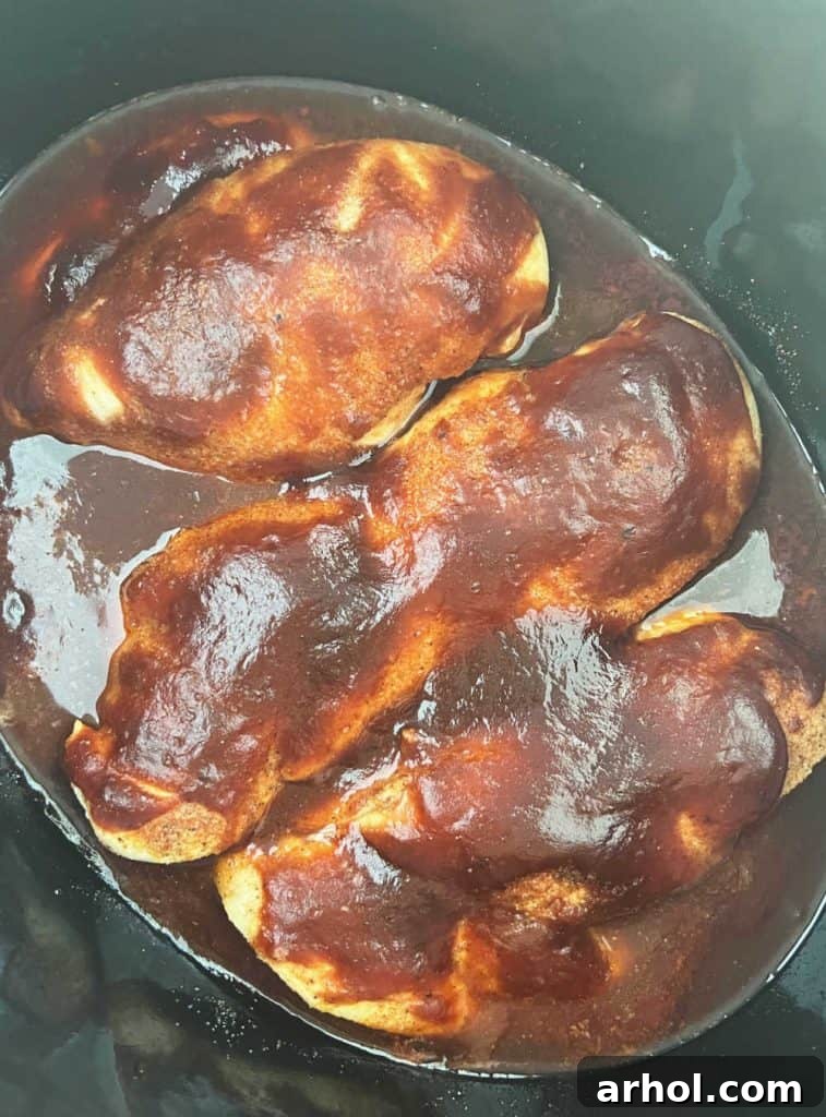 Irresistible Slow Cooker BBQ Pulled Chicken 5 chicken smothered in bbq sauce in slow cooker