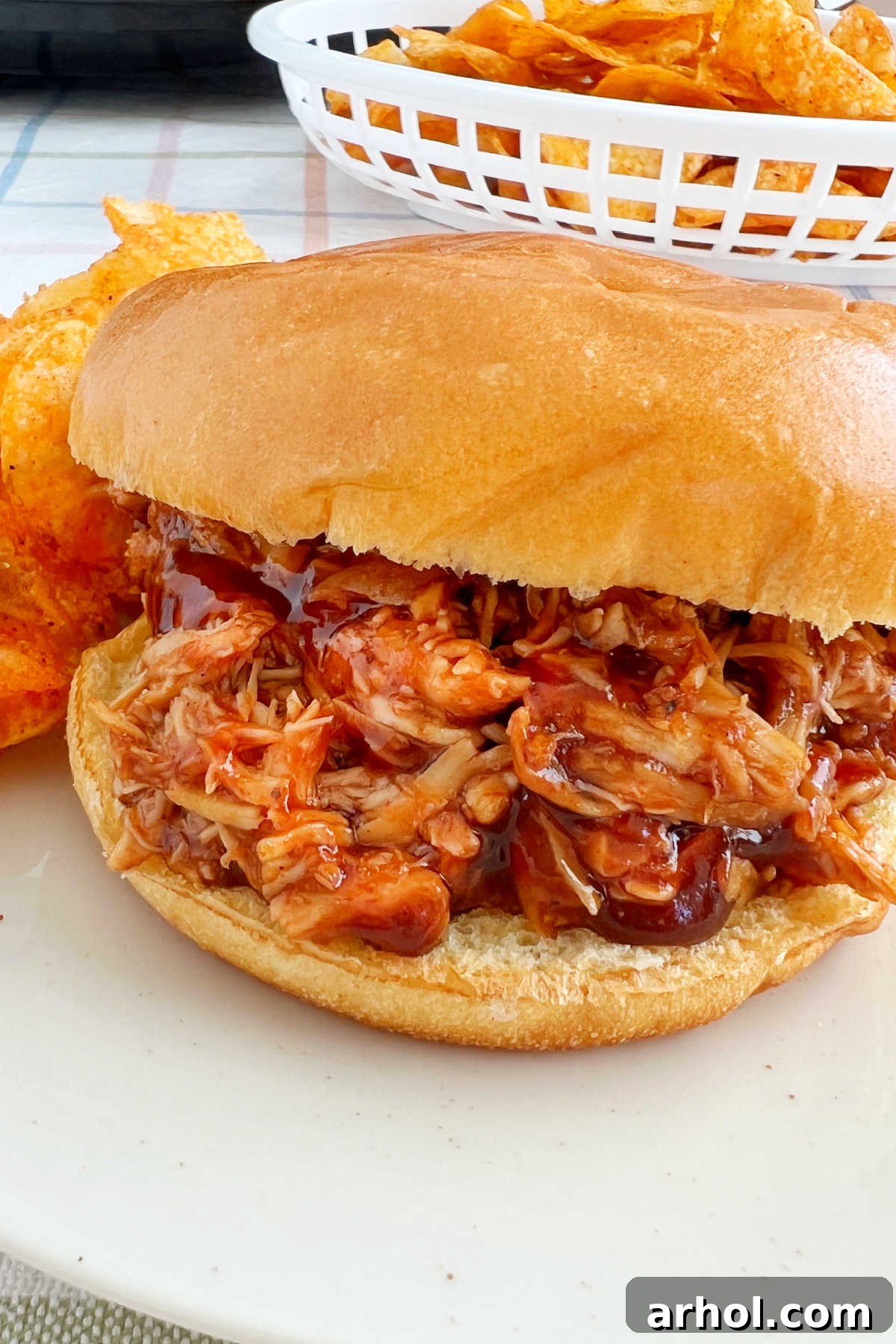 Irresistible Slow Cooker BBQ Pulled Chicken 7 crock pot bbq chicken sandwich on plate with potato chips