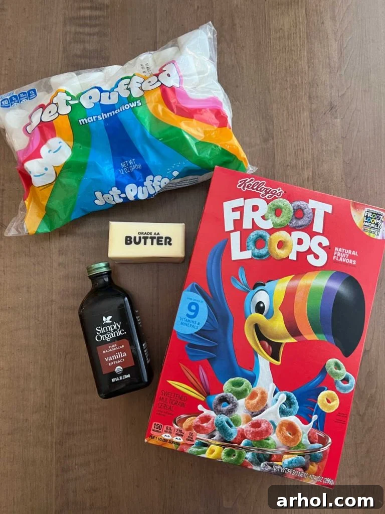 All the necessary ingredients for Froot Loop Bars laid out: a vibrant box of Froot Loops cereal, a soft bag of marshmallows, a stick of golden butter, and a bottle of pure vanilla extract.